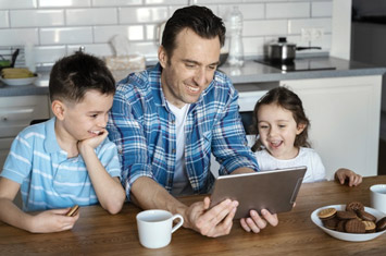 Father Using iPad With Children